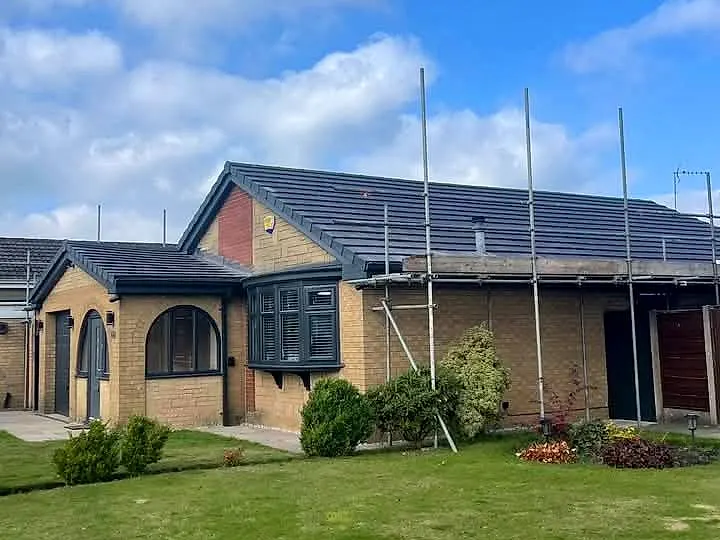 Bungalow re-roofed by R+R Roofing with new dark grey tiles, scaffolding still in place