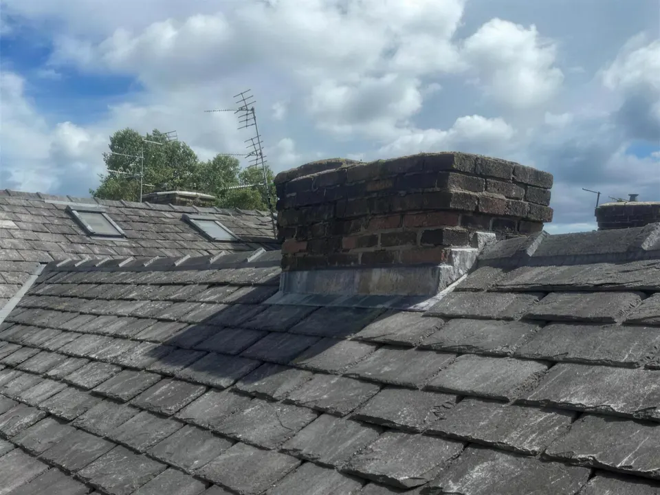Brick chimney stack above a slate roof