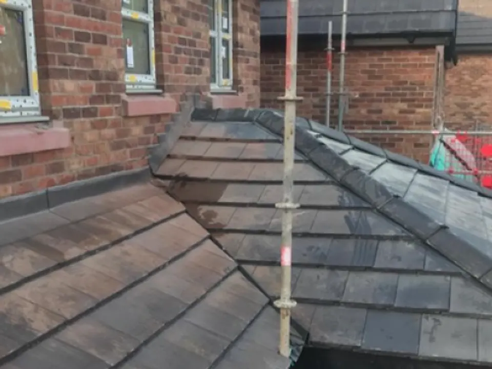 Re-slate in progress behind scaffolding