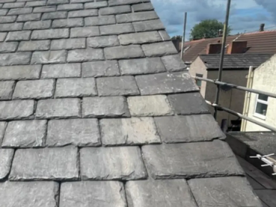 Slate roof repair in progress with replacement slates